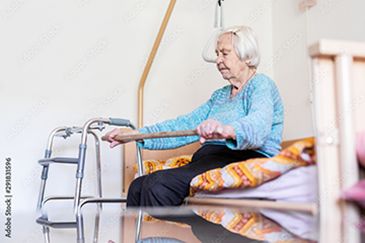 Elderly woman using walker with caregiver support